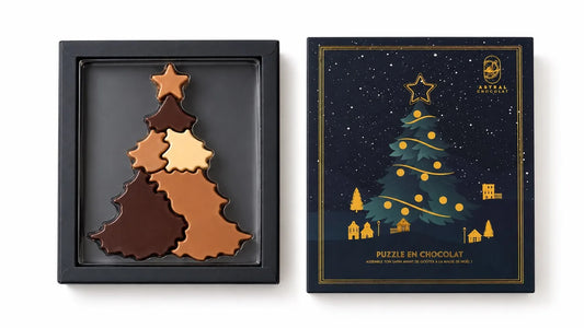 Sapin de Noël en chocolat Astral en pièces à assembler, à côté de sa boîte bleu nuit